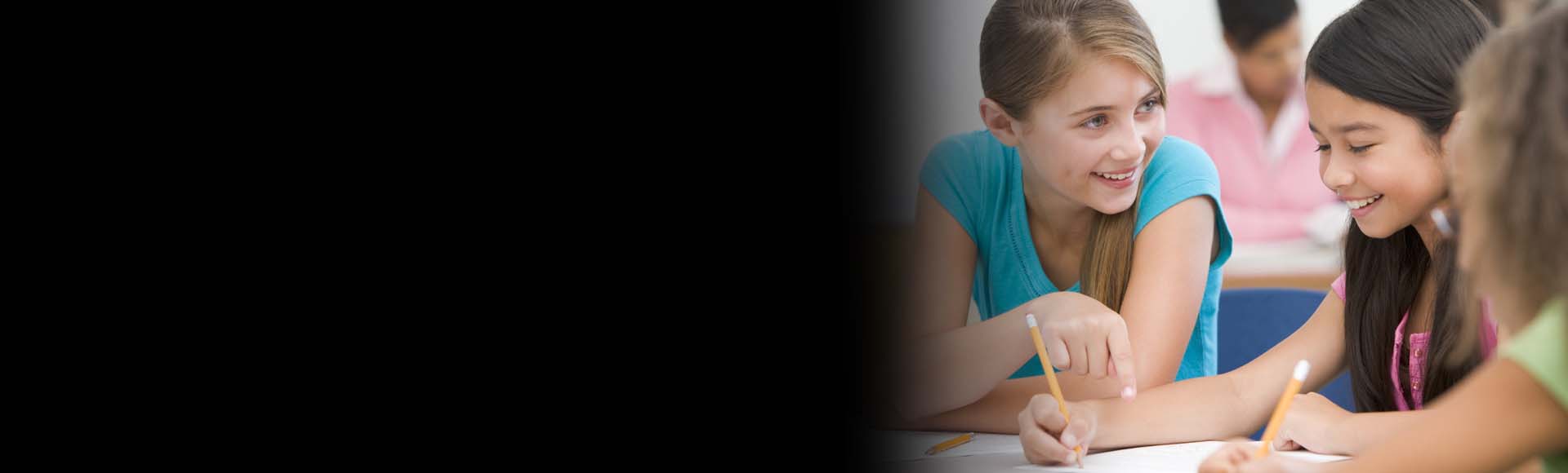 students smiling at desk